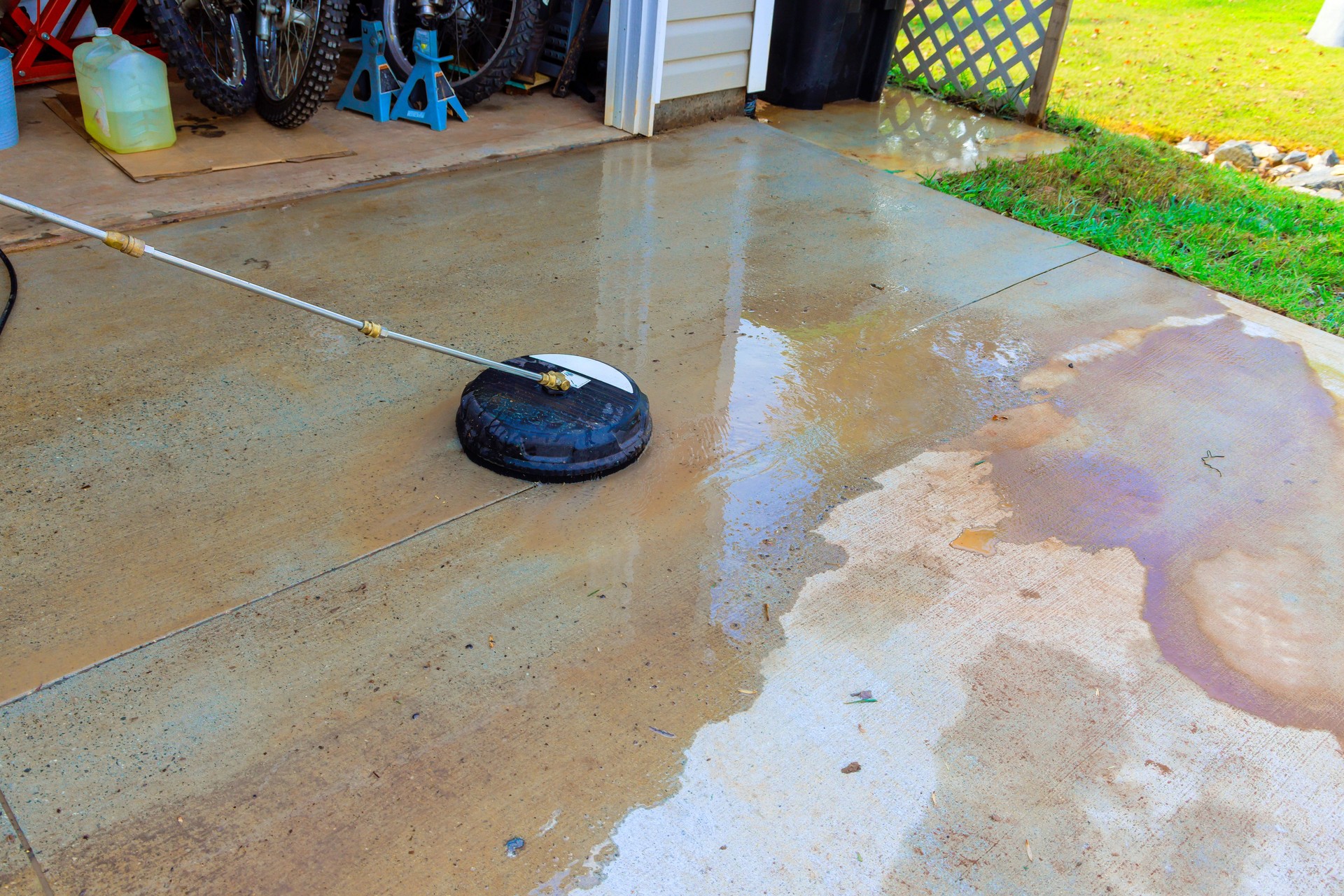 High-pressure cleaning of a driveway in a residential garage on a sunny day